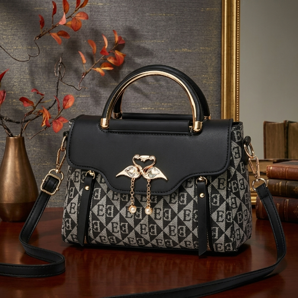 Black and gray patterned handbag with gold accents on a wooden surface.