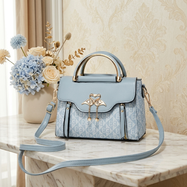 Light blue handbag with floral design on a marble surface with decorative flowers in the background.