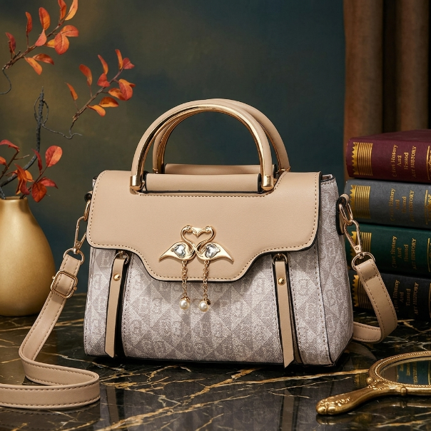 Designer handbag with decorative elements on a marble surface with books and flowers in the background