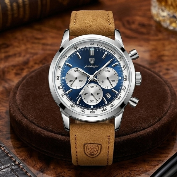 Luxury watch with brown leather strap and blue dial on a wooden surface