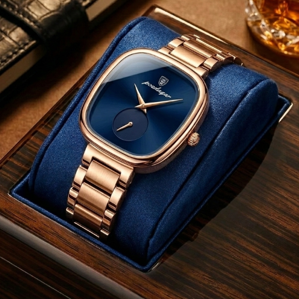 Luxury watch with rose gold strap and blue face in a display case on a wooden surface.
