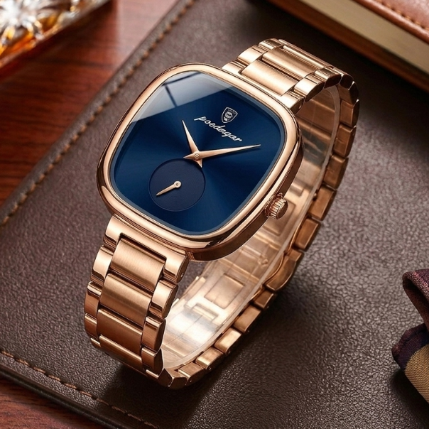 Rose gold watch with blue dial on a brown leather surface