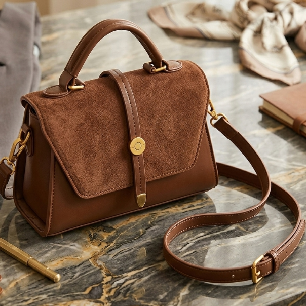 Brown handbag with gold accents on a marble surface