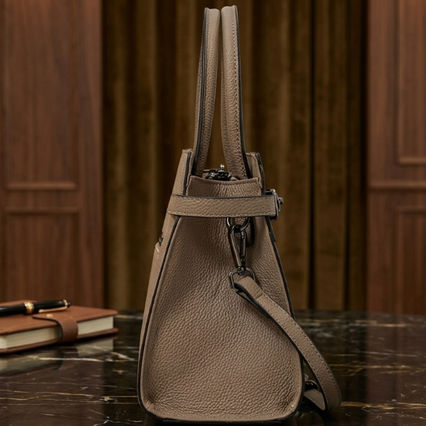 Brown leather handbag on a dark marble surface with a wooden panel background