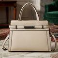 Beige handbag on a marble surface with a blurred indoor background