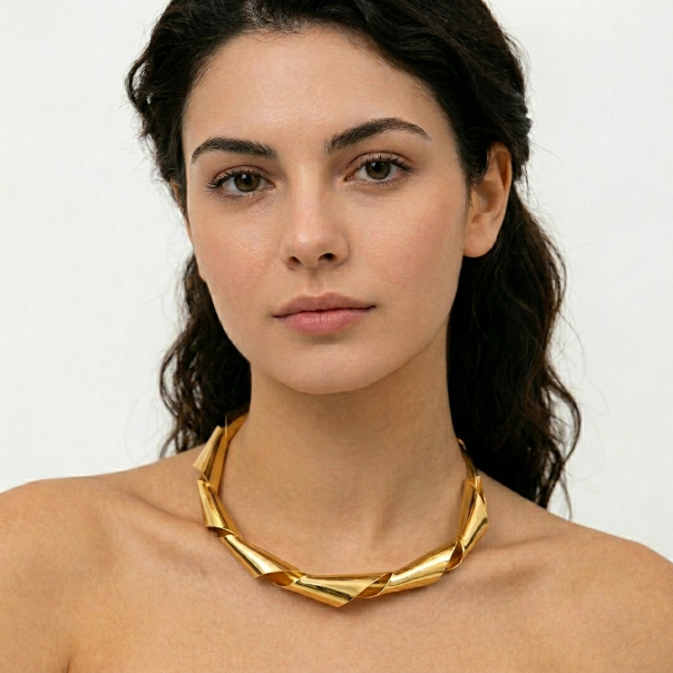 Woman wearing a gold necklace against a plain background