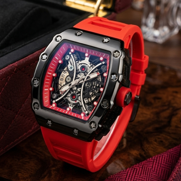 Watch with a red strap and intricate face on a wooden surface