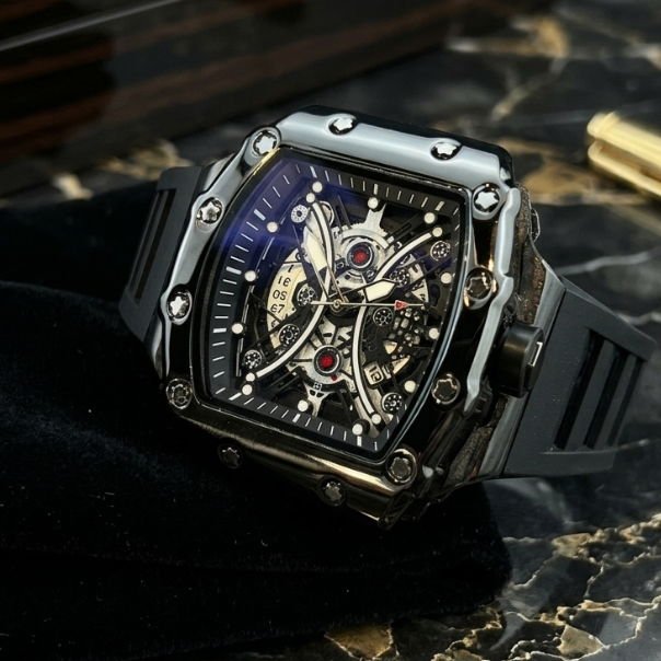 Luxury black wristwatch with intricate design on a dark marble surface