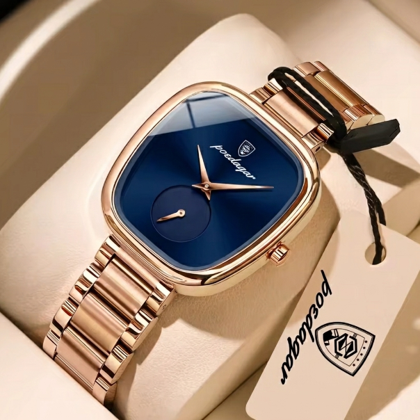 Luxury watch with rose gold strap and blue dial on a beige cushion, branded 'Patek Philippe'.