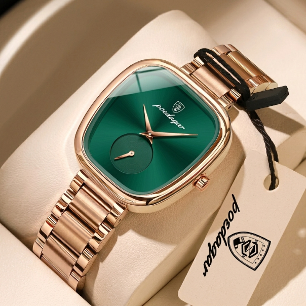 Gold watch with green face on a beige cushion, branded 'Patek Philippe'.