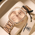 Rose gold watch with a brand tag on a beige background